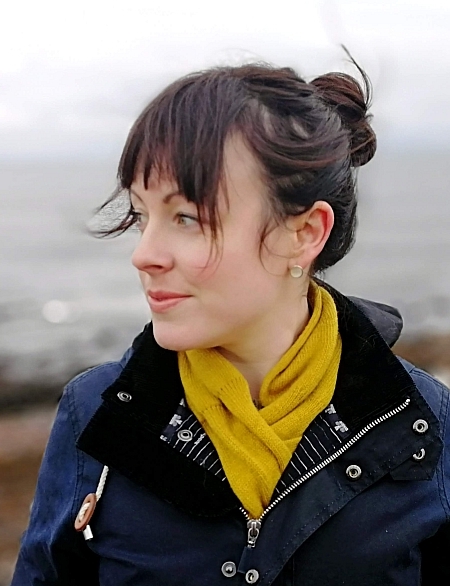 Head and shoulders shot of Dr Laura Mair in warm outdoor clothes with the sea behind